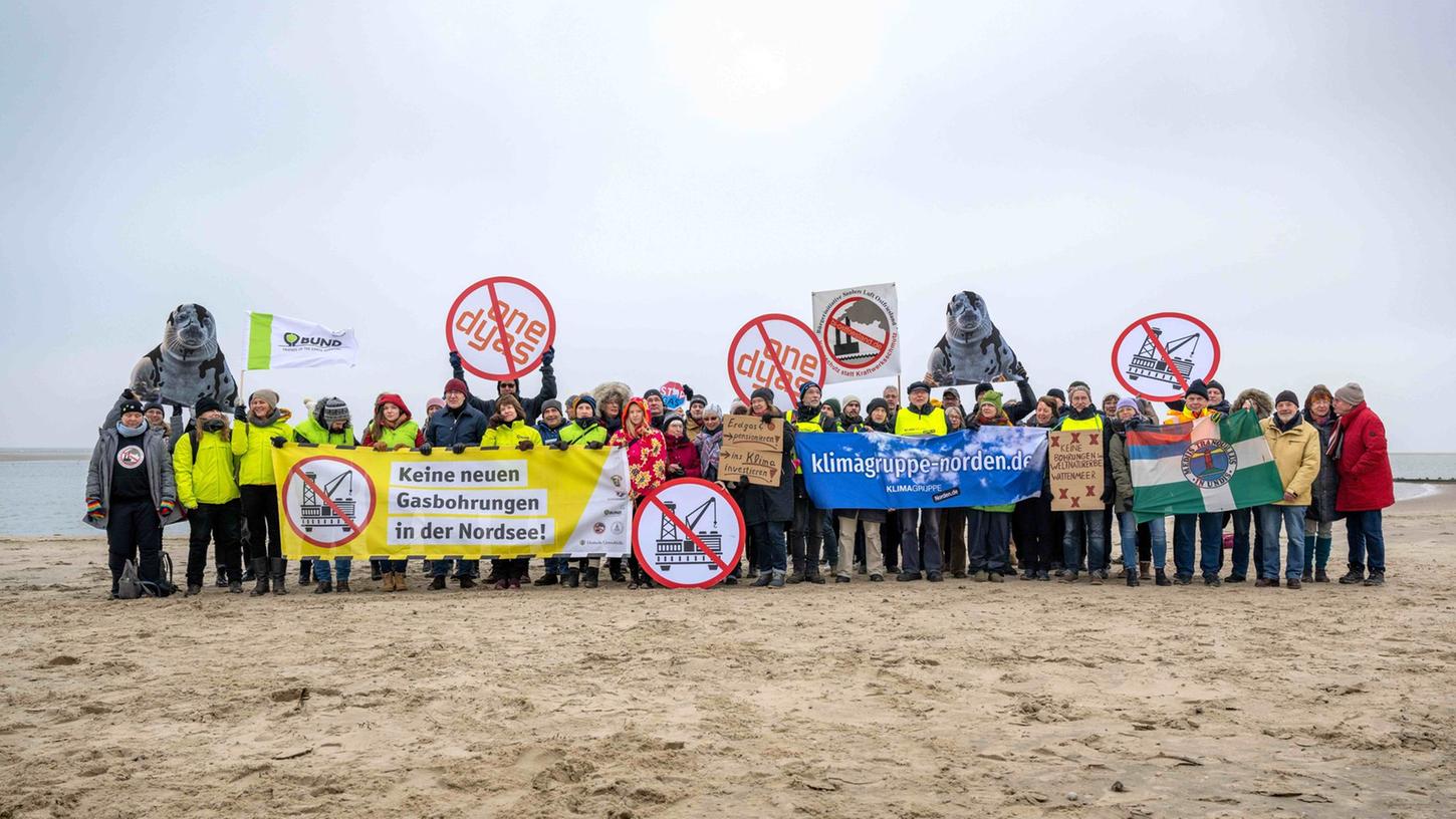 Umweltschützer und Insulaner demonstrieren am Weststrand von Borkum mit Bannern und Plakaten gegen die geplante Erdgasförderung.
