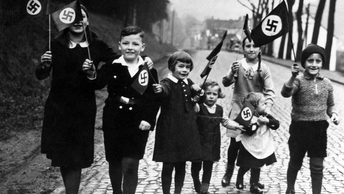 Propagandafoto für die Presse: Kinder mit Hakenkreuzfahnen in einer Szene aus der Dokumentation "Berlin 1933 - Tagebuch einer Großstadt".