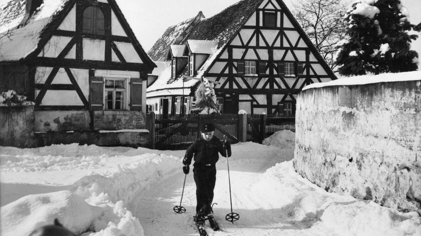 Ein Junge auf Skiern auf dem Weg durch das verschneite Stadeln. Mehr reizvolle historische Bilder aus allen Jahreszeiten in Fürth gibt es hier.