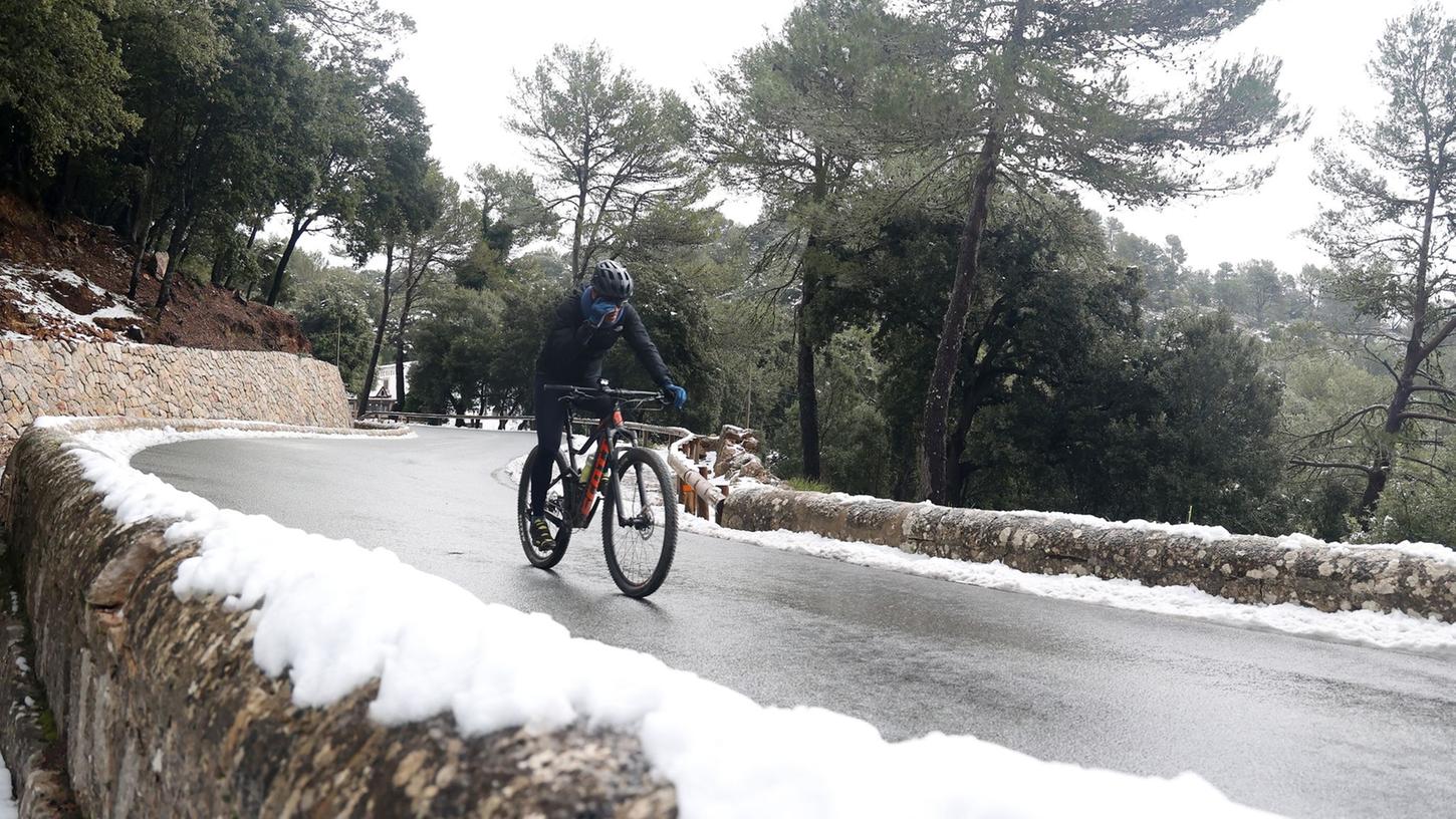 Ja, richtig geschaut. Auch auf der spanischen Urlaubsinsel kann es mal schneien. Ein Radfahrer trotzt den kalten Temperaturen in der Serra de Tramuntana.