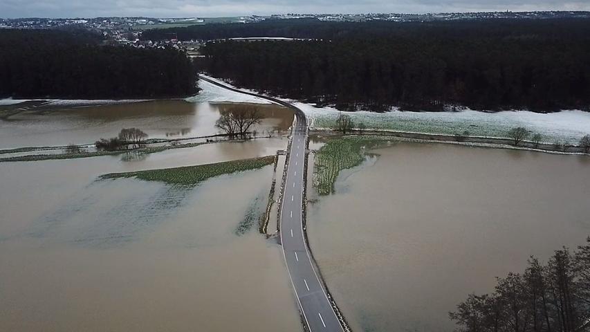 Bei Kleinsendelbach im Landkreis Forchheim tritt Wasser über die Ufer und überschwemmt ganze Felder und Wiesen.
