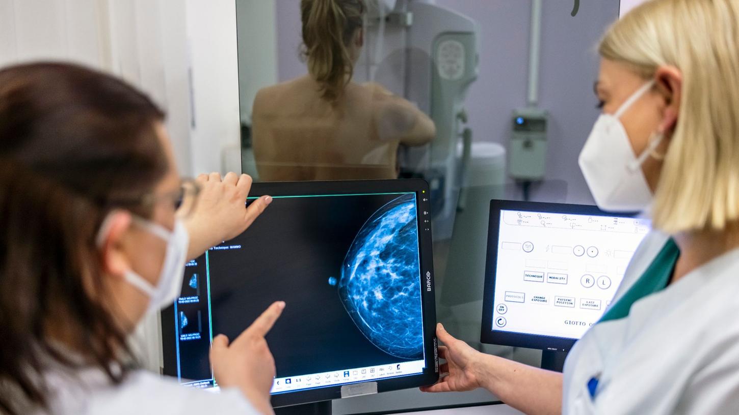 Medizinisches Personal untersucht mit einer Mammografie die Brust einer Frau auf Brustkrebs.
