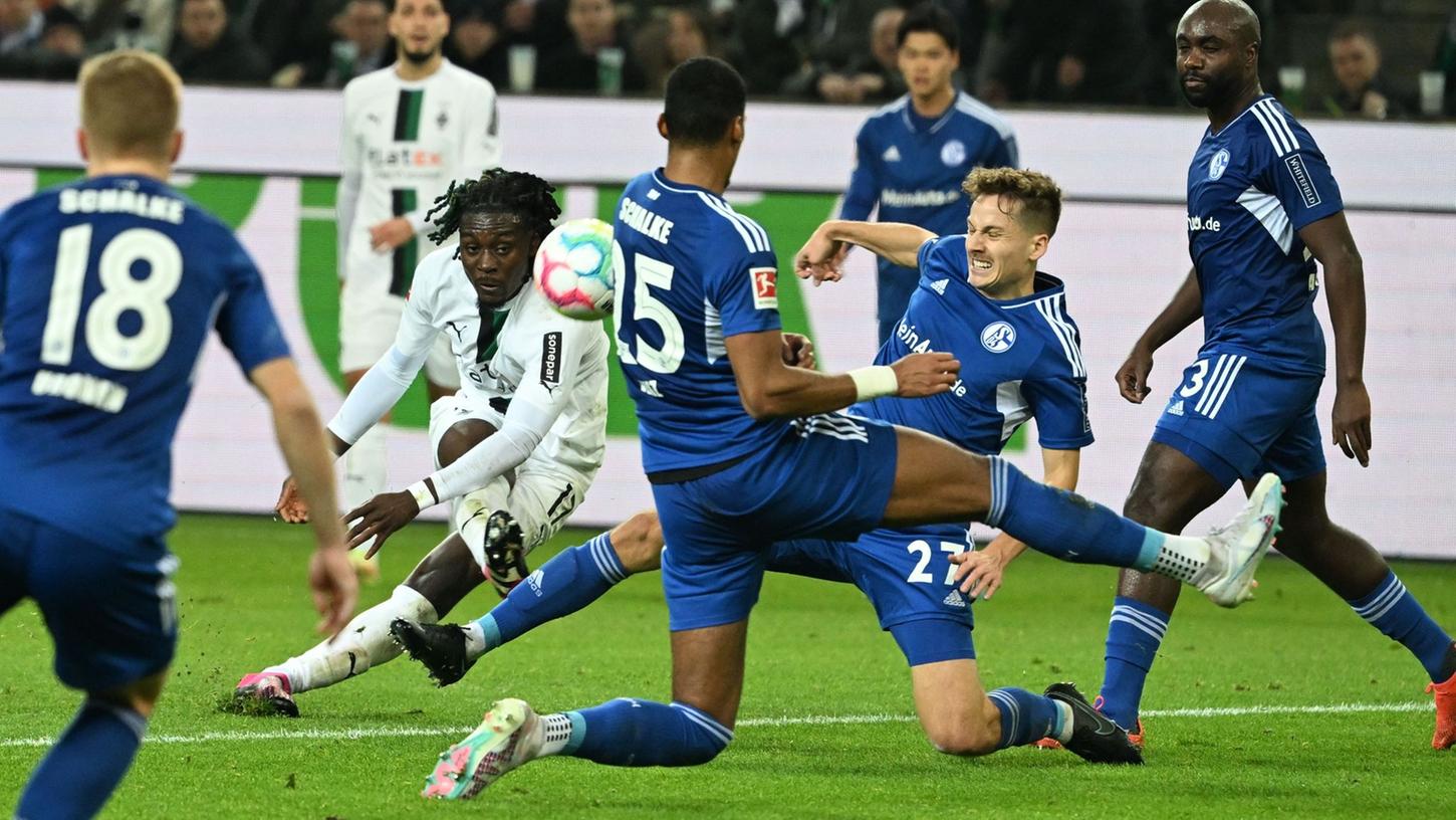 Zwei Schalker werfen sich in den Schuss von Mönchengladbachs Manu Koné.