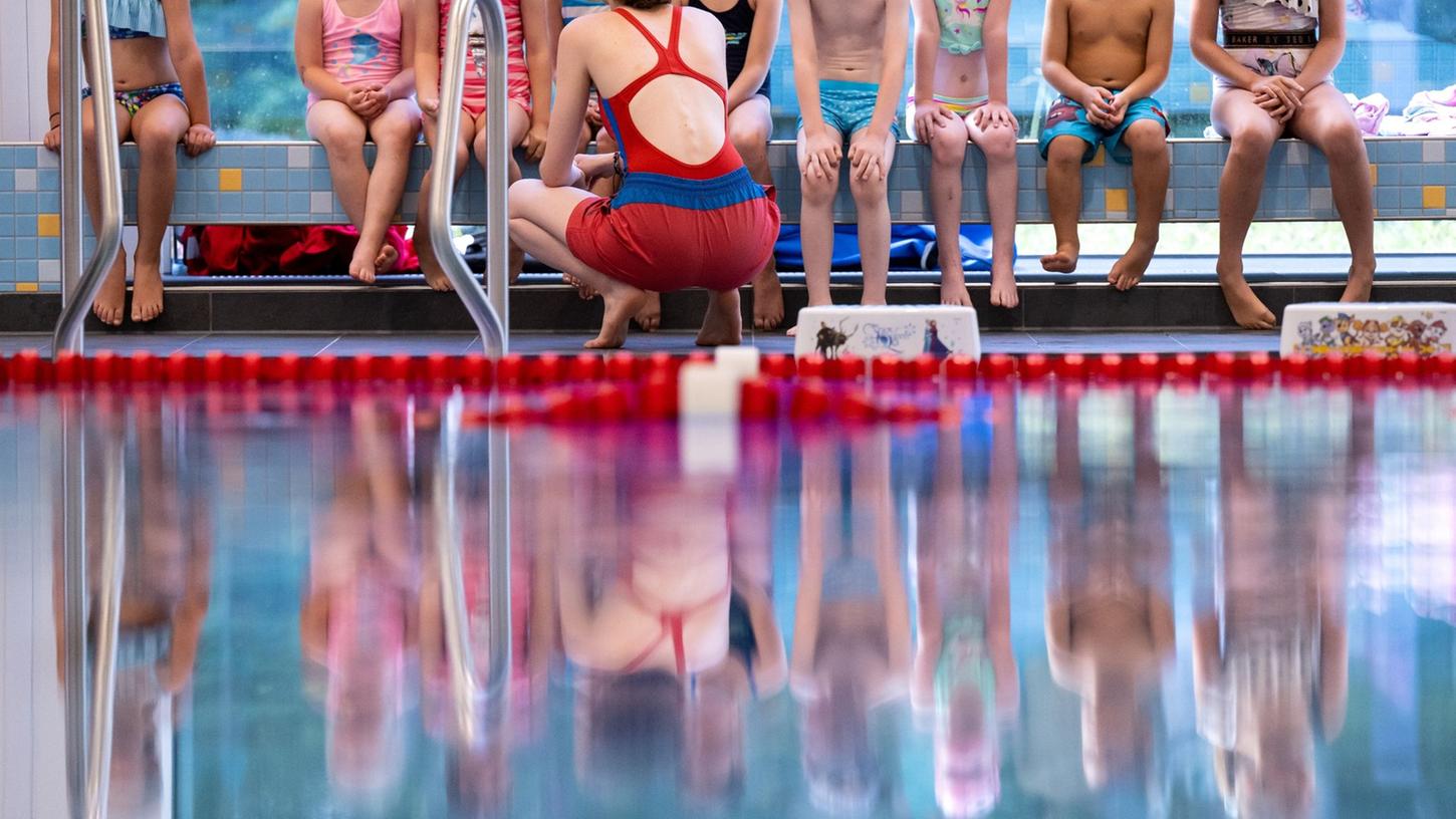 Kinder nehmen an einem Schwimmkurs teil.
