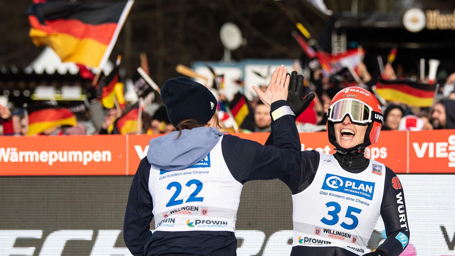 Skispringerin Katharina Althaus (r) jubelt nach ihrem Sieg mit Teamkollegin Anna Rupprecht (l).