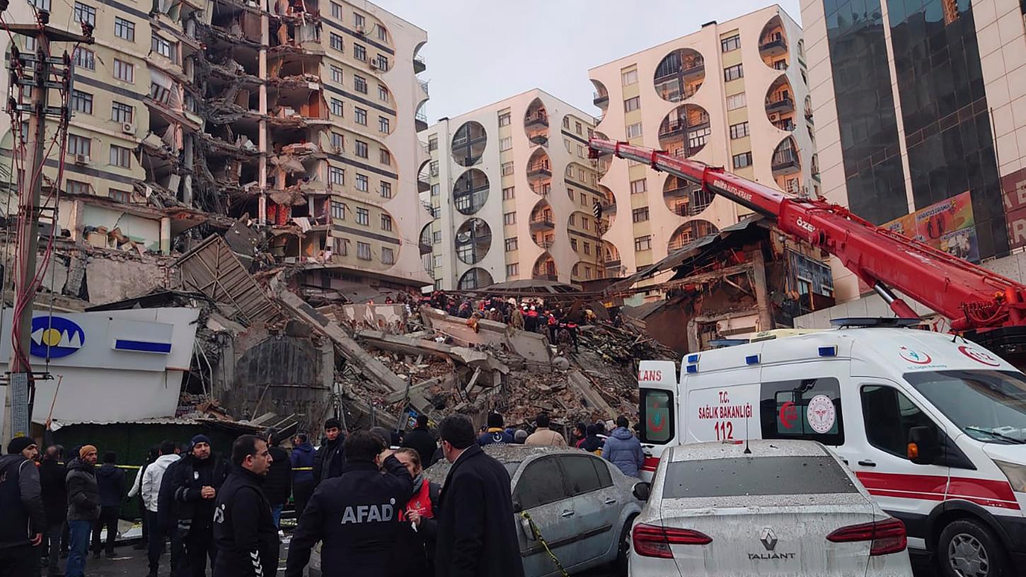 Rettungskräfte und medizinische Teams versuchen, nach einem Erdbeben in Diyarbakir im Südosten der Türkei, verschüttete Bewohner in einem eingestürzten Gebäude zu erreichen. 