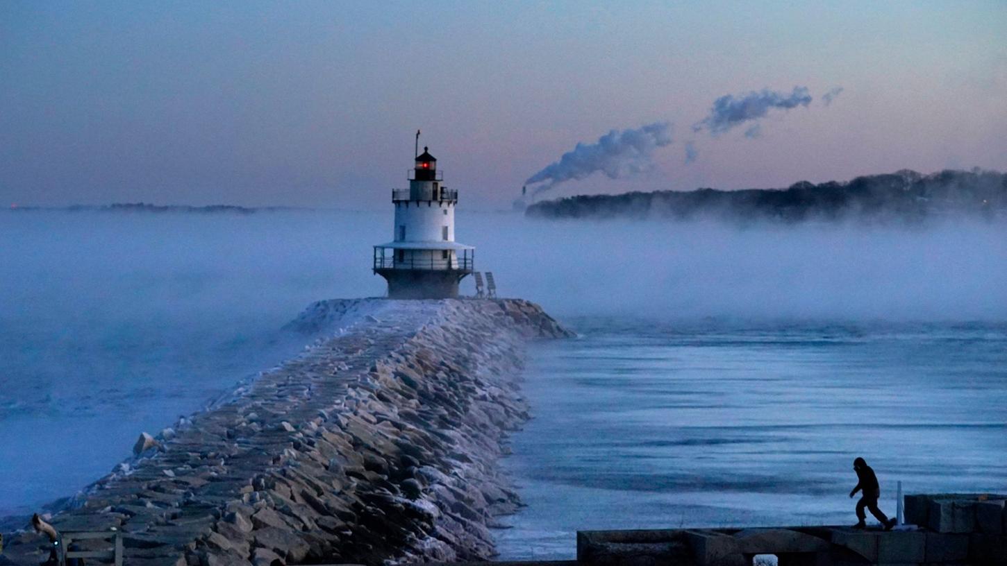 Bei -23 Grad Celsius geht ein Mann auf dem Deich in der Nähe des "Spring Point Ledge Light" im US-Bundesstaat Maine spazieren. Bei -23 Grad Celsius geht ein Mann auf dem Deich in der Nähe des "Spring Point Ledge Light" im US-Bundesstaat Maine spazieren.