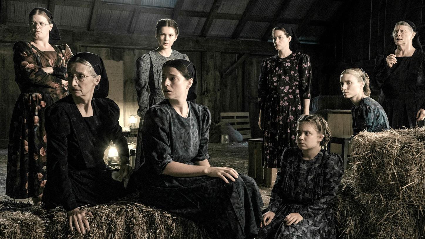 Michelle McLeod (l-r) als Mejal, Sheila McCarthy als Greta, Liv McNeil als Neitje, Jessie Buckley als Mariche, Claire Foy als Salome, Kate Hallett als Autje, Rooney Mara als Ona und Judith Ivey als Agata in einer Szene des Films "Die Aussprache".