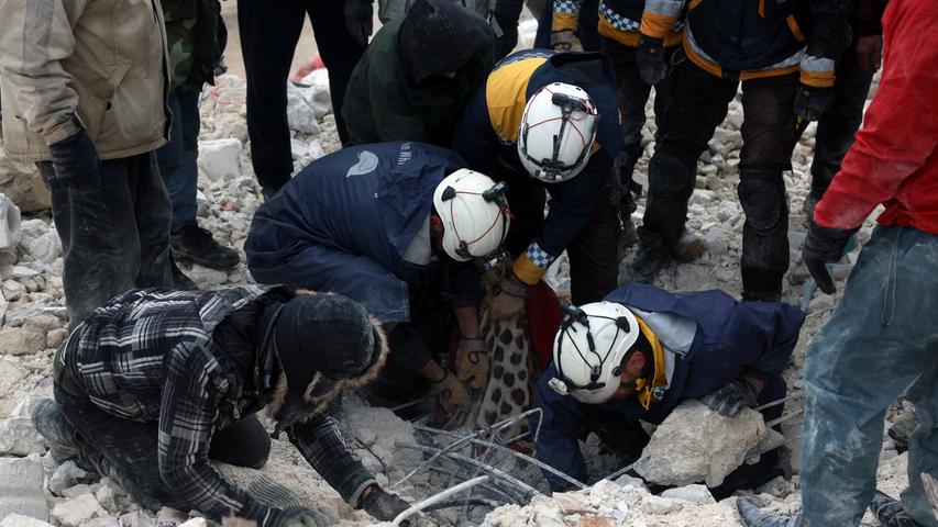Mitarbeiter des Zivilschutzes durchsuchen die Trümmer eingestürzter Gebäude nach Verschütteten. Nach mehreren schweren Erdbeben in der türkisch-syrischen Grenzregion steigt die Zahl der Toten weiter an.