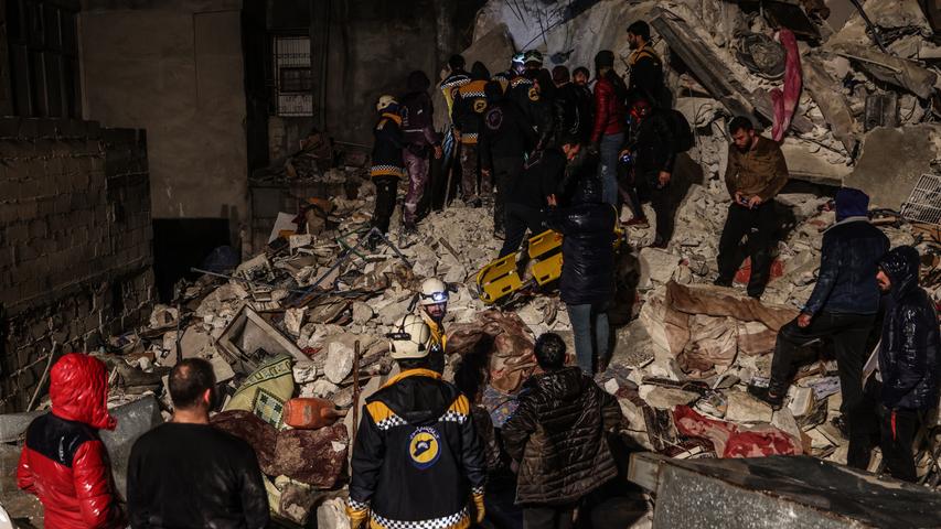 Syrische Zivilisten und Mitglieder der Weißhelme arbeiten an der Rettung von Menschen.