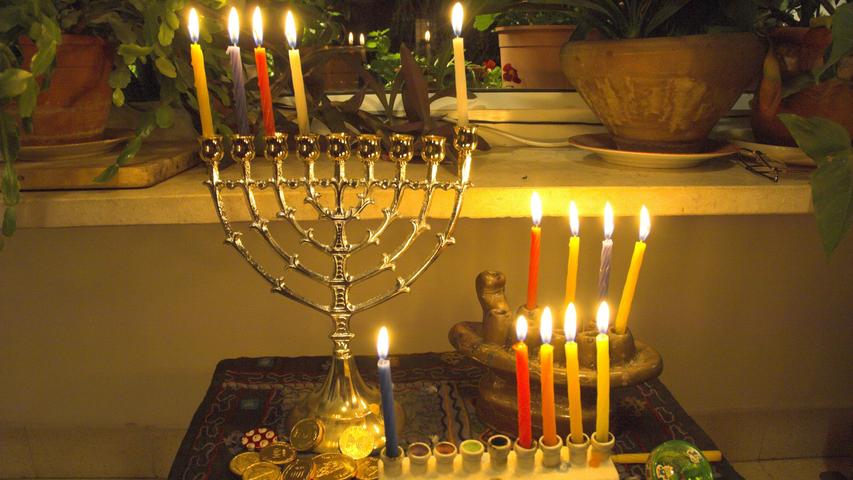 Drei Chanukkia mit vier brennenden Kerzen. Die fünfte Kerze, die in zwei der drei Leuchter steckt, dient dem Anzünden und wird nicht mitgezählt.