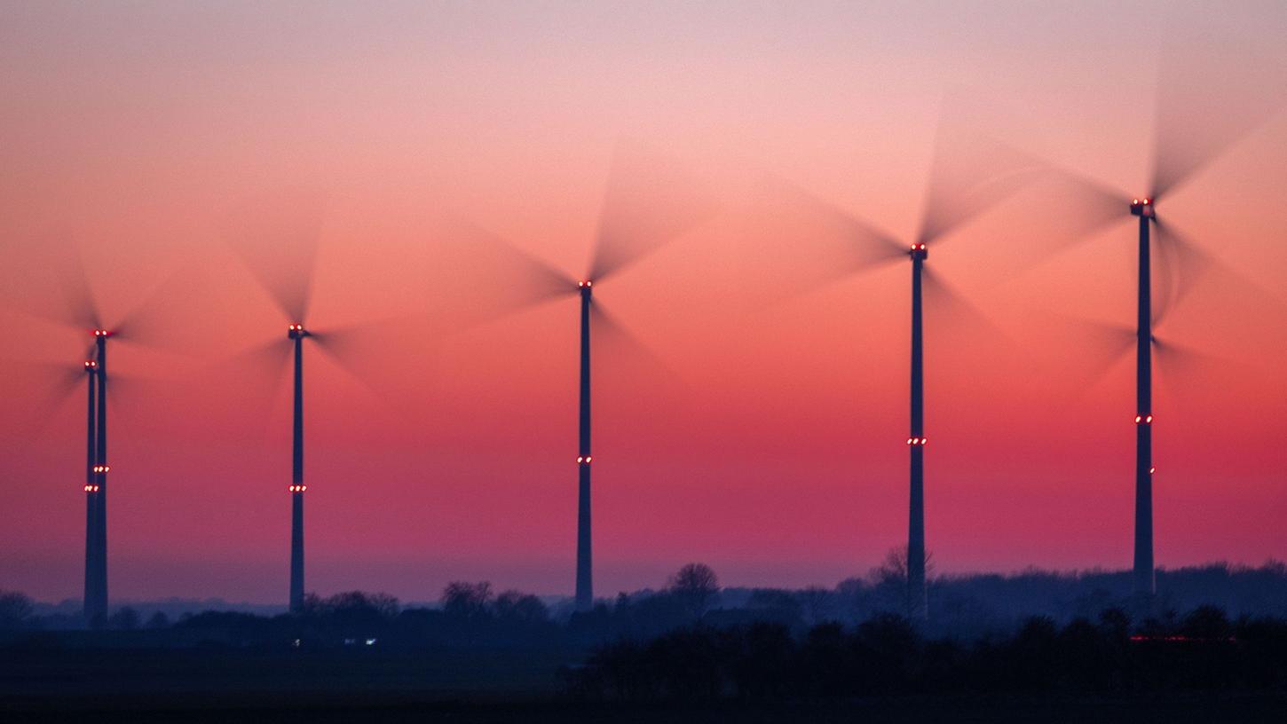 Die Rotoren von Windkraftanlagen drehen sich nach Sonnenuntergang in Bützow (Mecklenburg-Vorpommern).