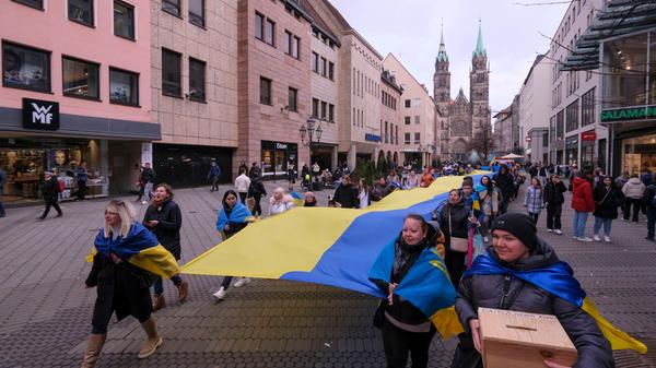 Schon tagsüber gedachten Aktivisten mit einer 24 Meter langen Fahne in der Nürnberger Innenstadt des Angriffskriegs gegen die Ukraine.