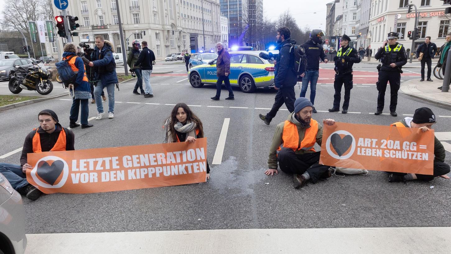 Aktivisten der Umweltgruppe "Letzte Generation" haben sich auf dem Hamburger Gorch-Fock-Wall und wollen damit auf Klimakrise aufmerksam machen.
