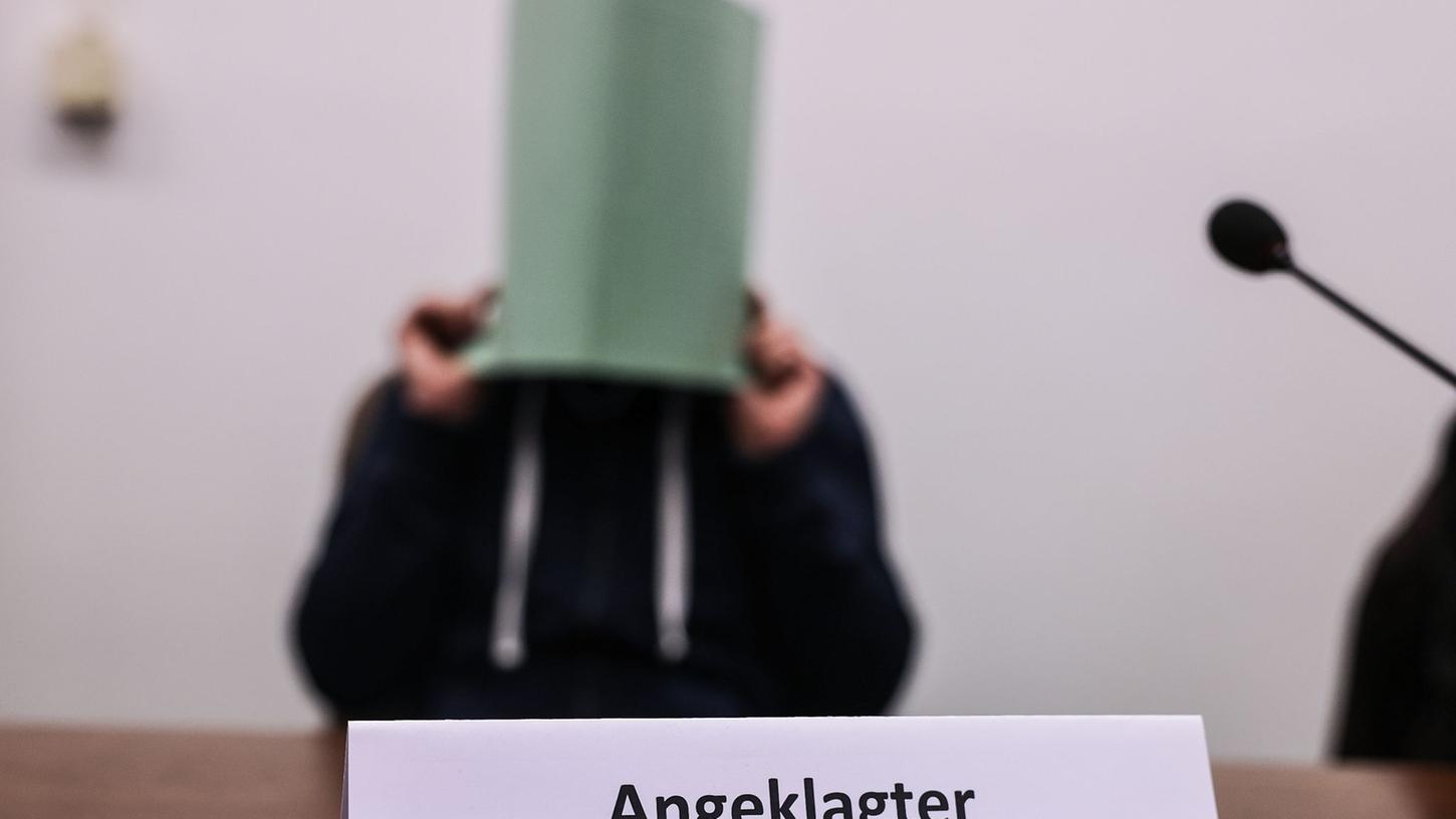 Der Angeklagte im Missbrauchskomplex Wermelskirchen hält sich im Gerichtssaal eine Mappe vor das Gesicht. Der Angeklagte im Missbrauchskomplex Wermelskirchen hält sich im Gerichtssaal eine Mappe vor das Gesicht.