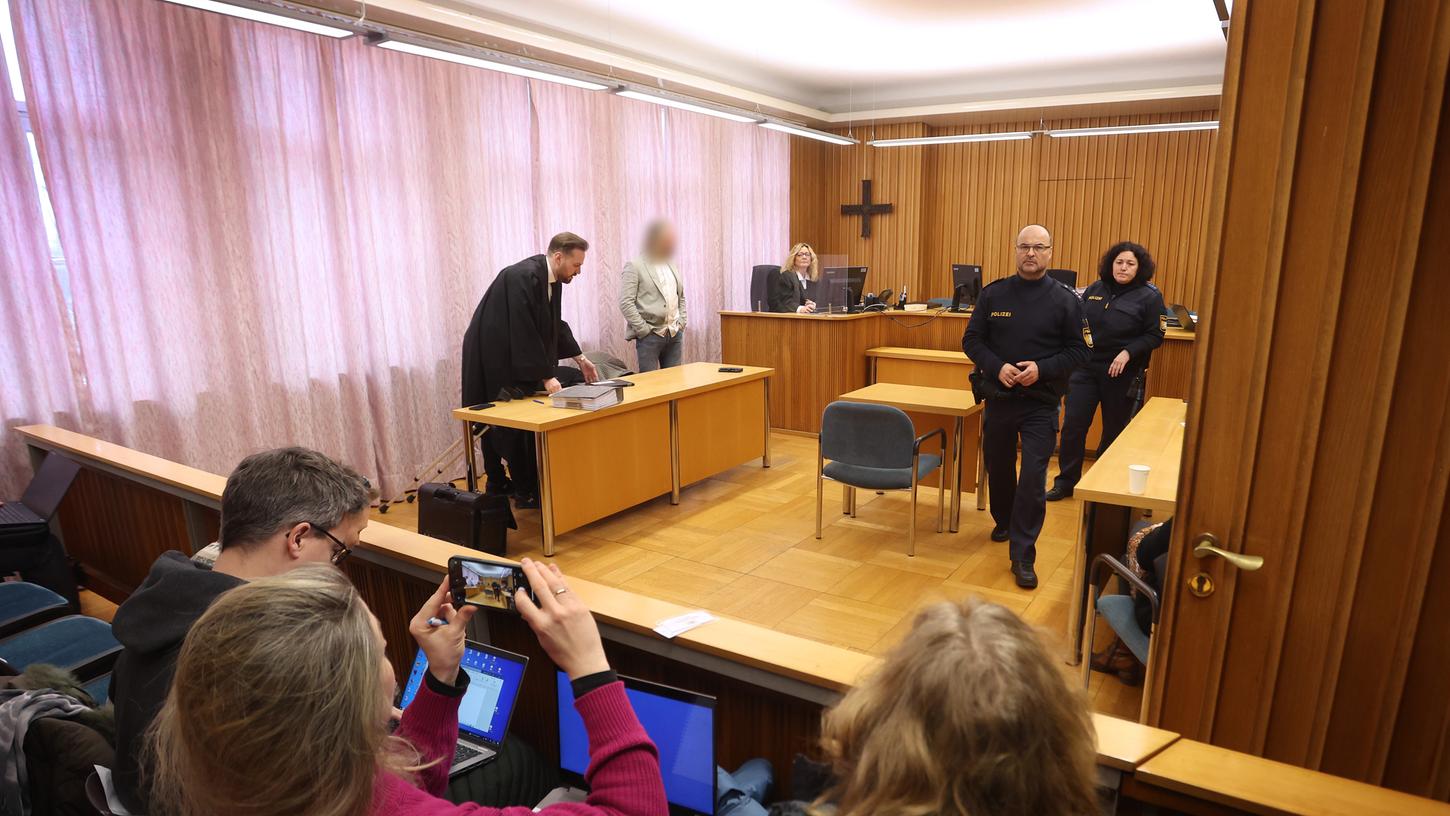 Ein Mann (hinten 2.v.l) steht im Amtsgericht in Landsberg am Lech vor der Anklagebank. Dem Arzt wird vorgeworfen, während der Corona-Pandemie in 117 Fällen Maskenbefreiungen ausgestellt zu haben, ohne die Empfänger der Atteste untersucht zu haben. 