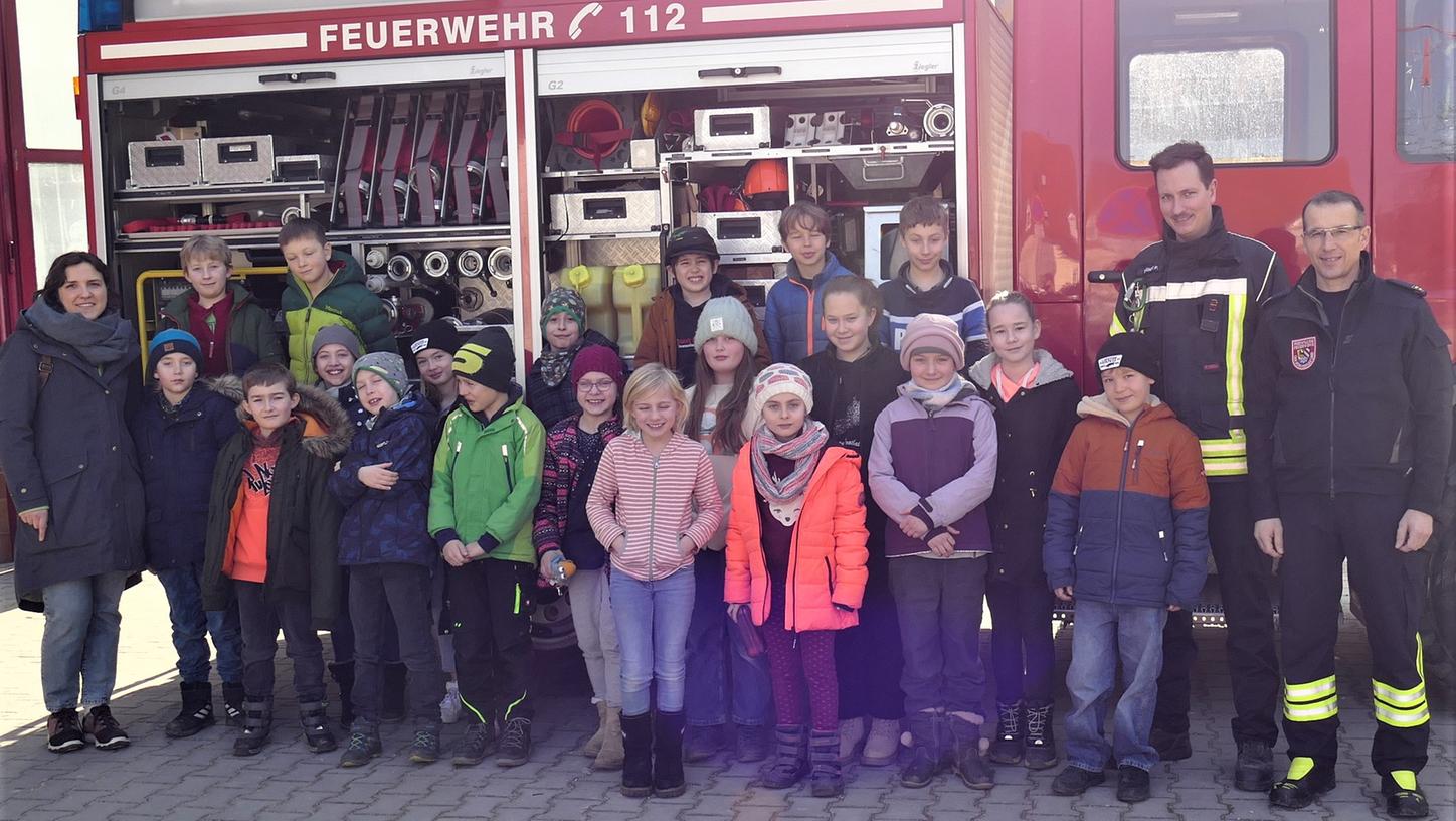 Unser Bild zeigt die Schüler der dritten Klasse mit ihrer Lehrerin Katharina Engelhardt sowie Patrick Bogner und Thomas Loos von der Happurger Feuerwehr.  