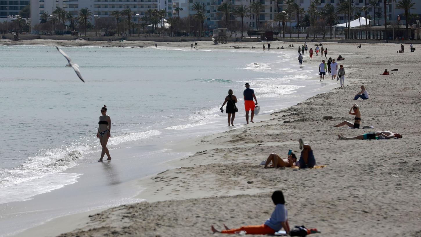 Menschen sonnen sich am Strand von Cala Millor auf Mallorca.