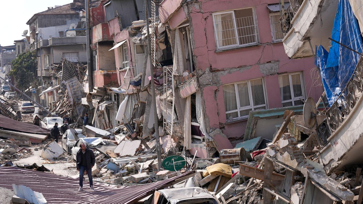 Ein Mann geht Anfang März über die Trümmer eingestürzter Gebäude im türkischen Hatay.