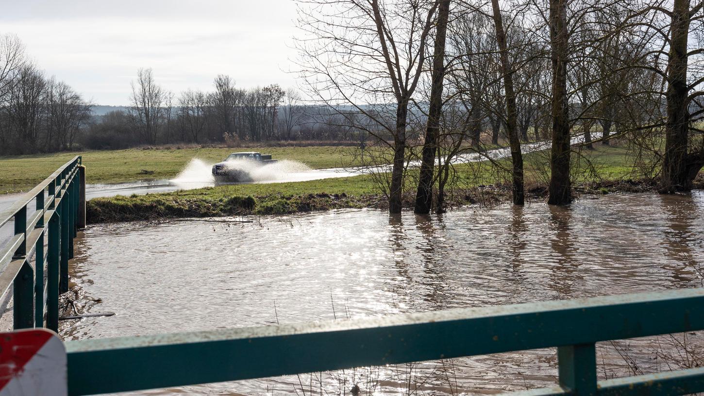 Ein Gelände-Pickup gischtet durch die leicht überflutete Zufahrtsstraße zur Laufer Mühle. Am Mittwochmittag wurde Meldestufe 2 mit 431 Zentimetern Pegel erreicht.