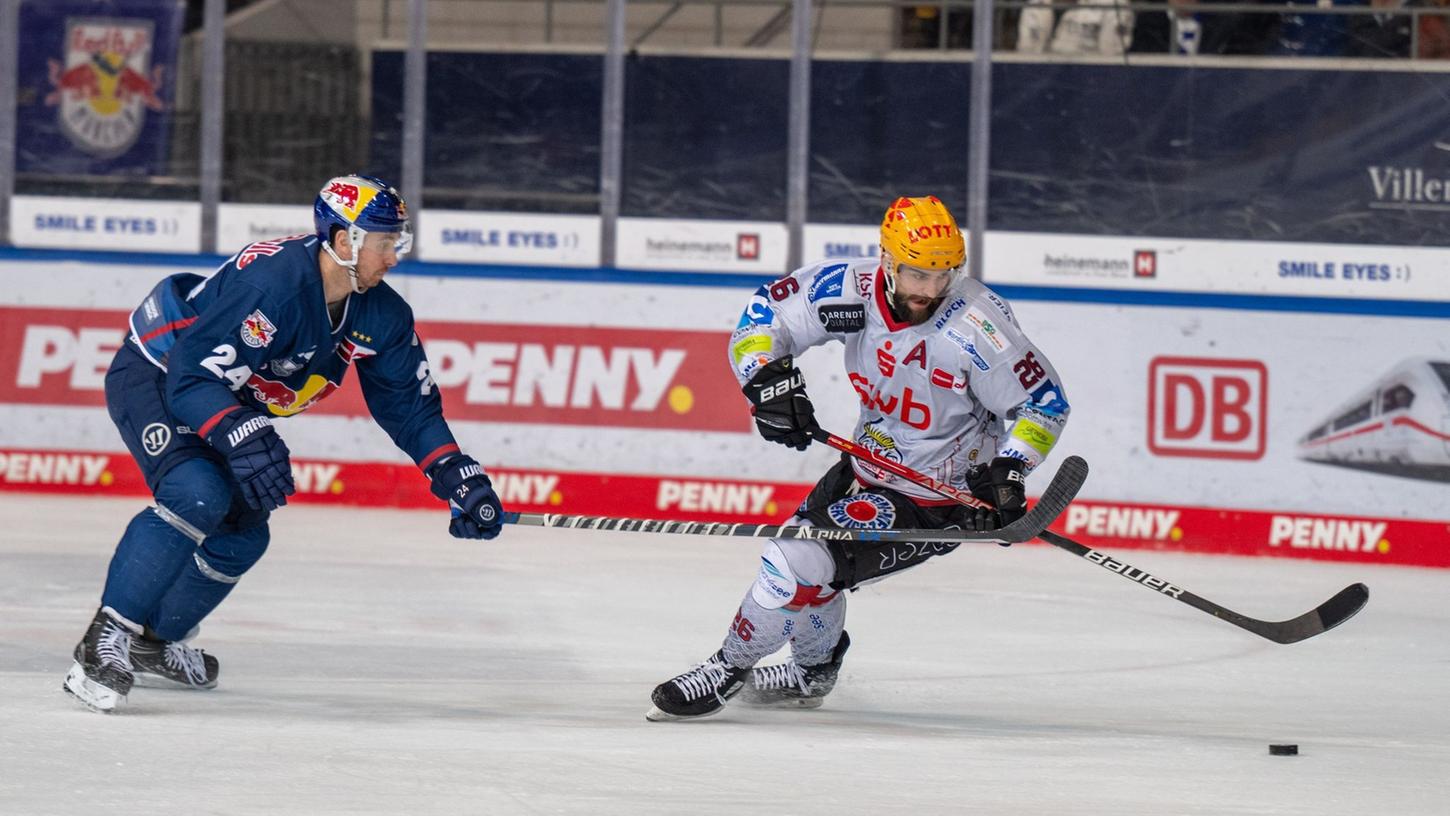 Der Bremerhavener Dominik Uher (r) behauptet den Puck gegen Jonathon Blum aus München. Der Bremerhavener Dominik Uher (r) behauptet den Puck gegen Jonathon Blum aus München.