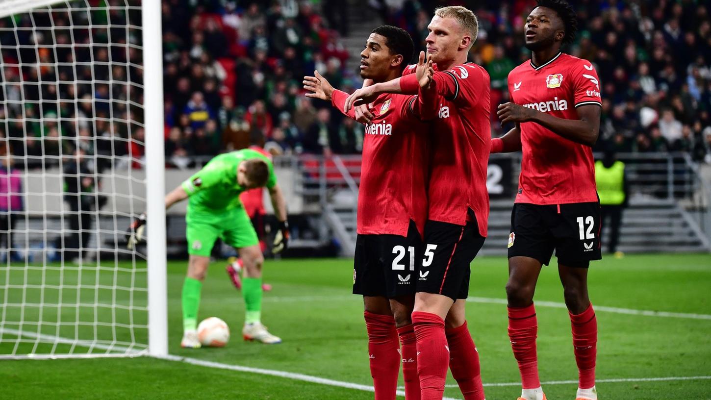 Leverkusens Torschütze Amine Adli (l-r) jubelt nach seinem Tor zum 0:2 mit Mitchel Bakker und Edmond Tapsoba.