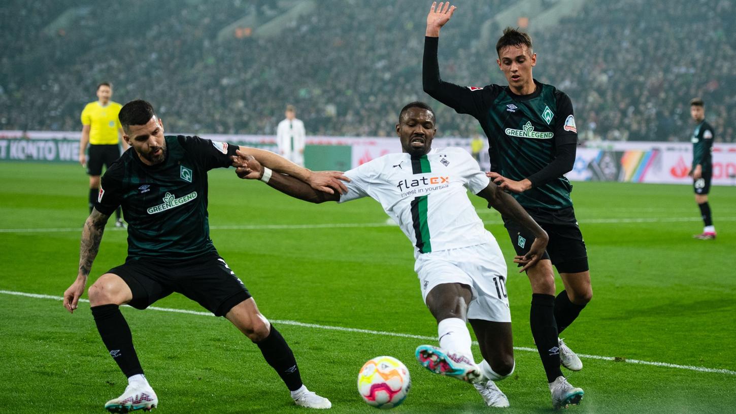 Gladbachs Marcus Thuram (M) kämpft mit Bremens Anthony Jung (l) und Fabio Chiarodia um den Ball. Gladbachs Marcus Thuram (M) kämpft mit Bremens Anthony Jung (l) und Fabio Chiarodia um den Ball.