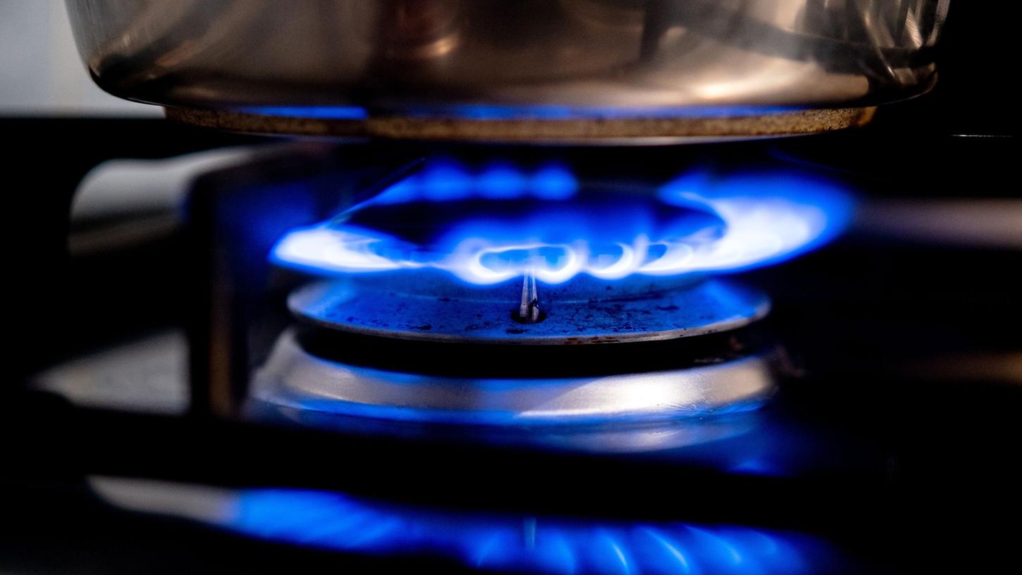 Eine Gasflamme brennt auf einem Küchenherd. Eine Gasflamme brennt auf einem Küchenherd.