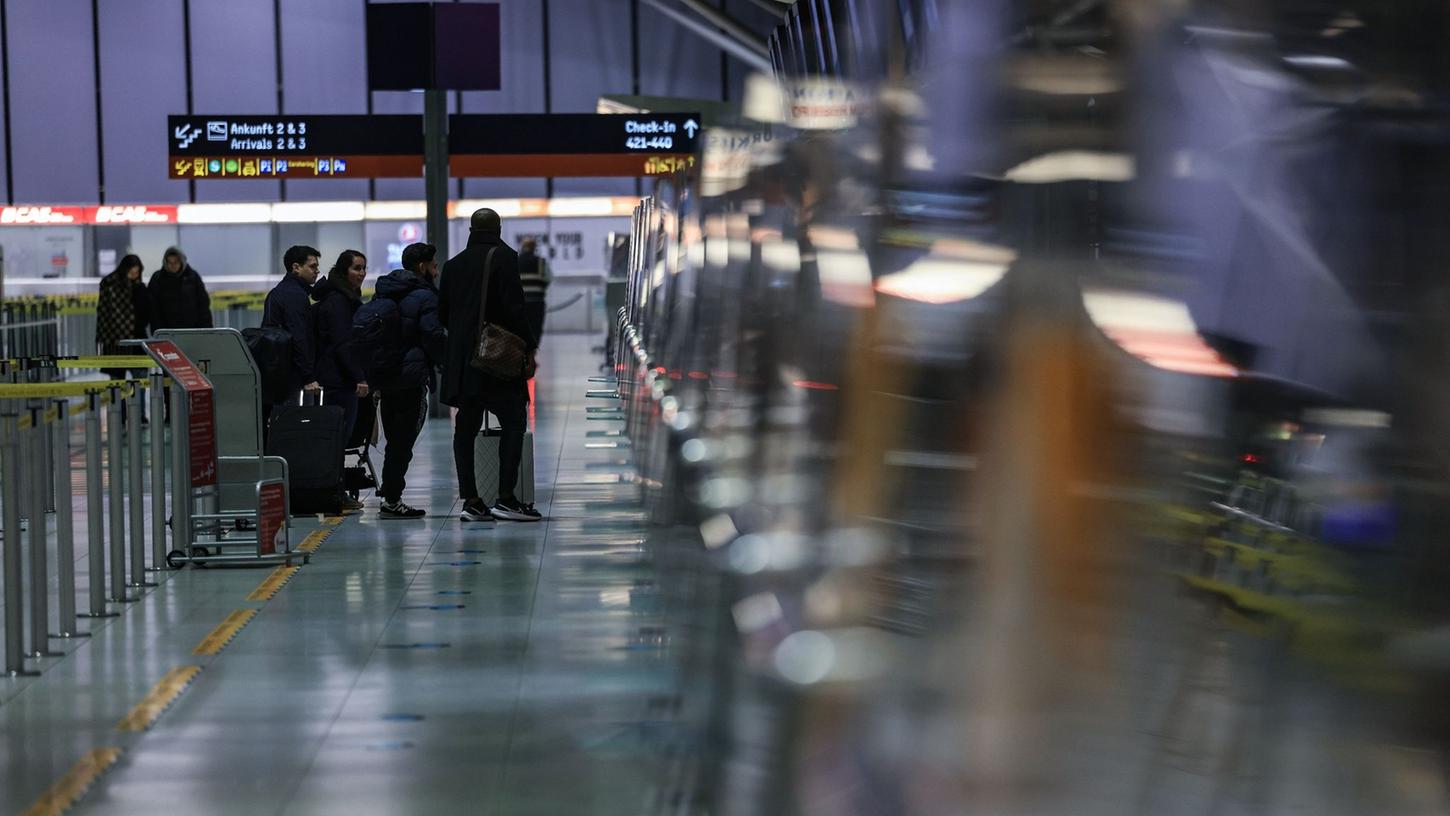 Reisende stehen am Flughafen Köln/Bonn vor einem Schalter. Reisende stehen am Flughafen Köln/Bonn vor einem Schalter.