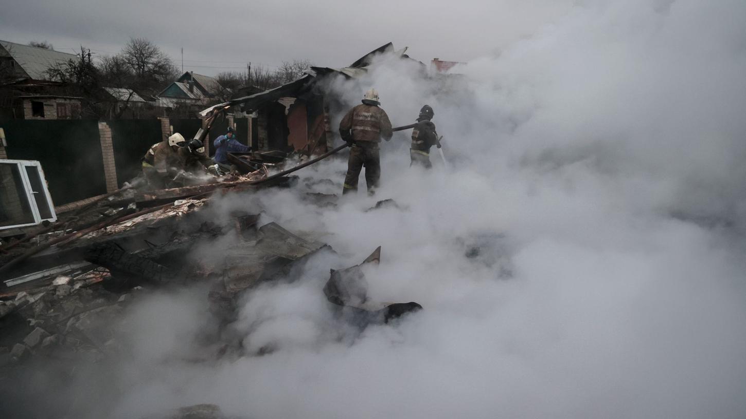 Feuerwehrleute löschen ein Feuer nach Beschuss im ukrainischen Charzysk.