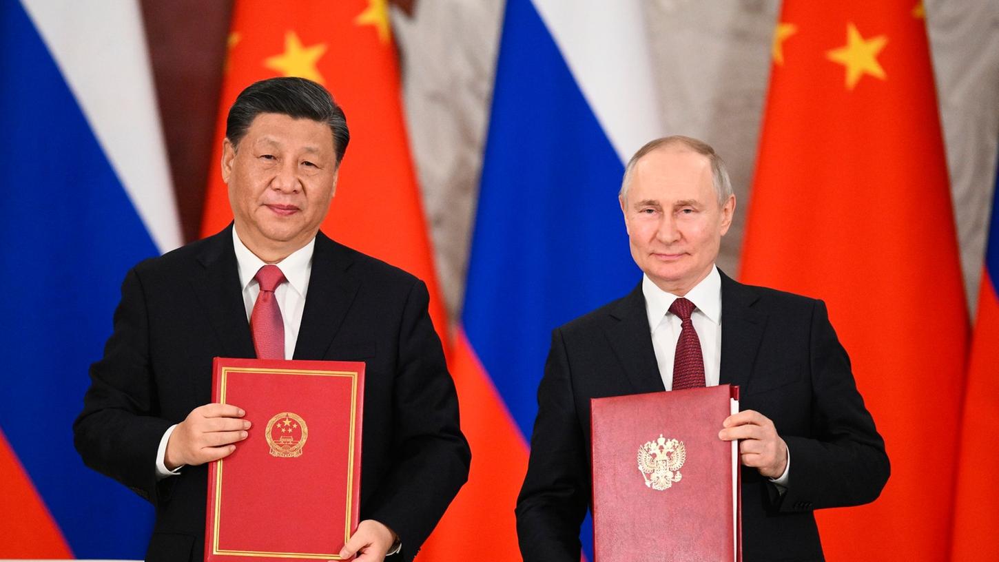 Chinas Präsident Xi Jinping und sein russischer Amtskollege Wladimir Putin zeigen während einer Unterzeichnungszeremonie Mappen mit den neuen Abkommen. Chinas Präsident Xi Jinping und sein russischer Amtskollege Wladimir Putin zeigen während einer Unterzeichnungszeremonie Mappen mit den neuen Abkommen.