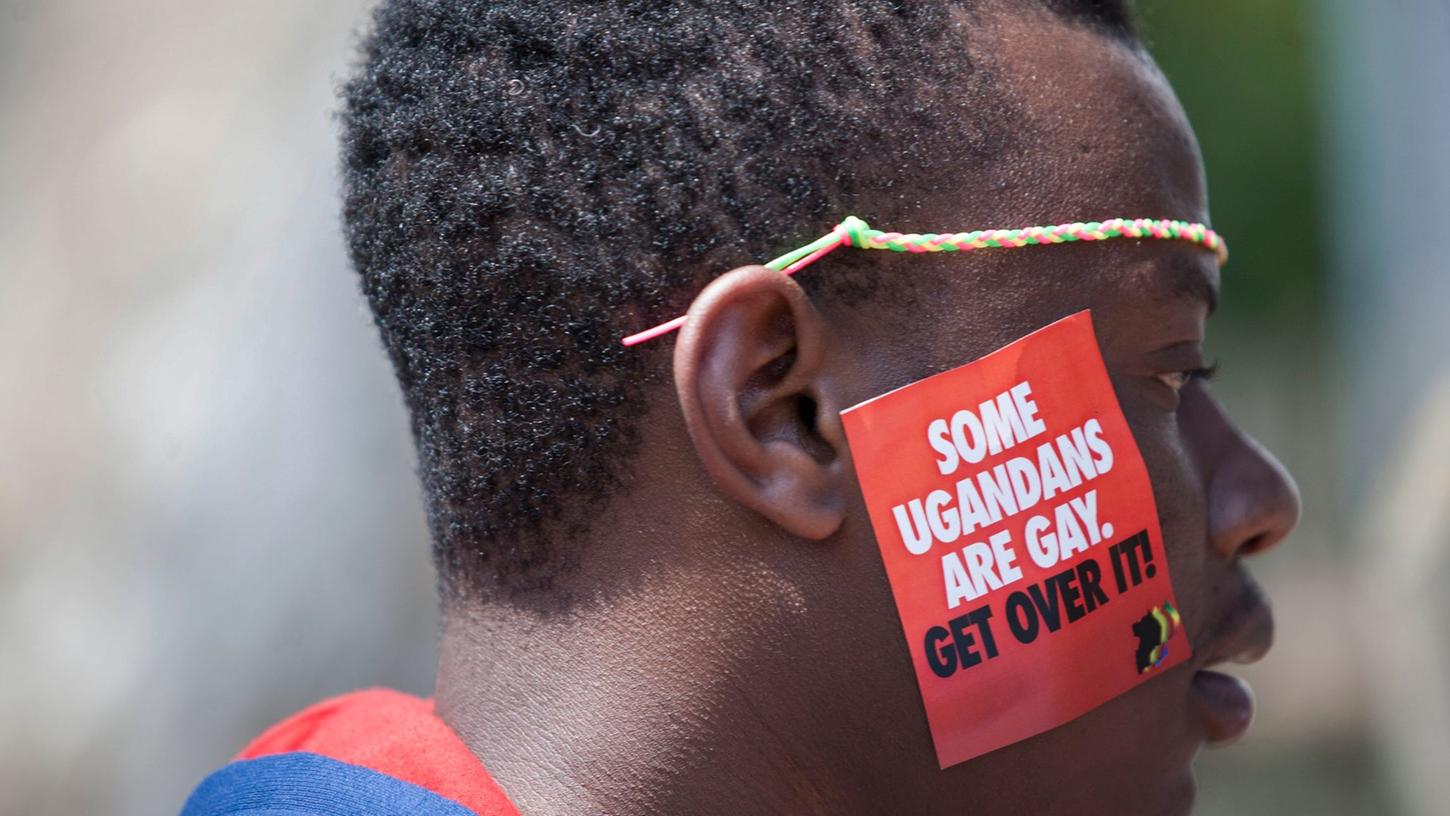 Ein Mann trägt bei LGBT-Pride-Feierlichkeiten in Entebbe einen Aufkleber mit der Aufschrift "Einige Ugander sind schwul. Finde dich damit ab" (Archivbild). Das ugandische Parlament hat für ein strenges Anti-Homosexuellengesetz votiert.