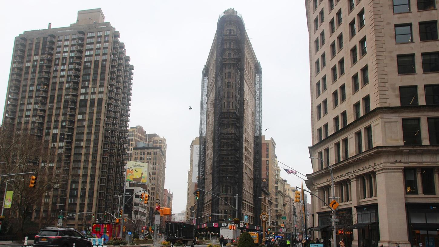 Das teilweise eingerüstete Flatiron Building in dem nach ihm benannten Flatiron District von Manhattan. Das teilweise eingerüstete Flatiron Building in dem nach ihm benannten Flatiron District von Manhattan.