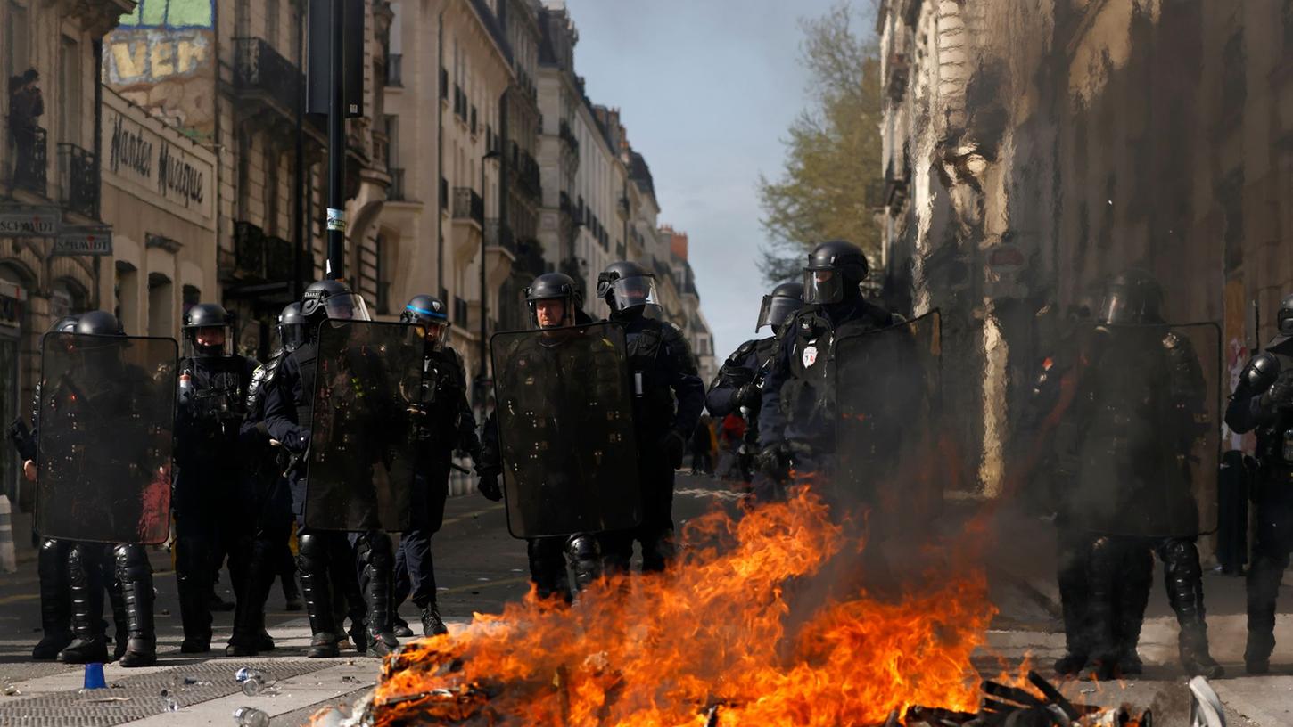 Bereitschaftspolizisten hinter einer brennenden Barrikade in Nantes. Bereitschaftspolizisten hinter einer brennenden Barrikade in Nantes.