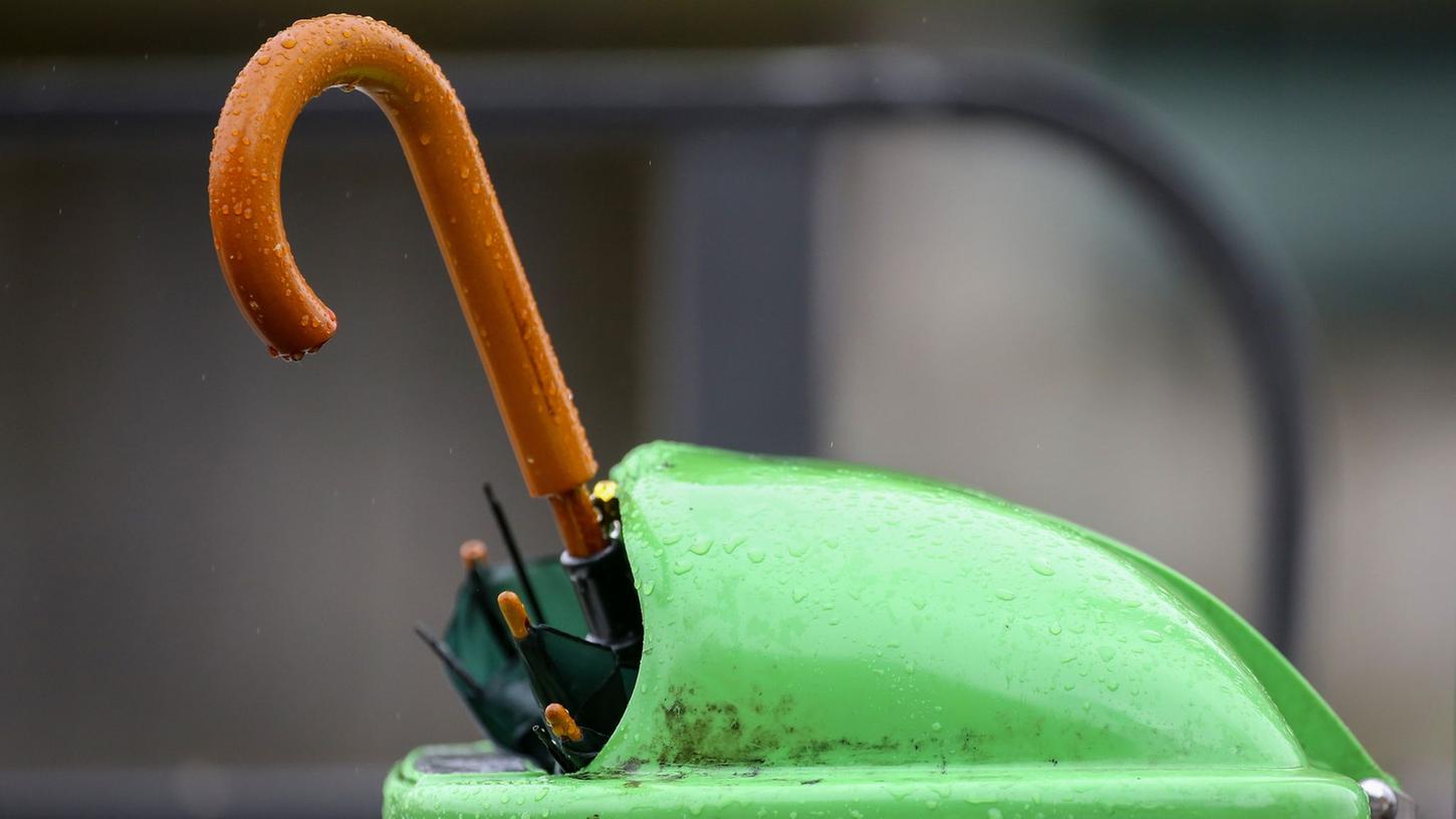 Kaputt? Ein weggeworfener Regenschirm steckt in einem Mülleimer.