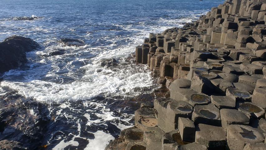 Eines der atemberaubendsten Naturdenkmäler Nordirlands ist Giant's Causeway, der "Damm des Riesen." Der Sage nach wurde der Riese Fionn McCumhaill von seinem schottischen Widersacher Benandonner so stark beleidigt, dass er sich dazu entschloss, diesen Damm zu errichten, um einen sicheren Weg nach Schottland zu bauen und ihn dort zu besiegen. Tatsächlich handelt es sich um rund 40.000 gleichmäßig geformte Basaltsäulen, deren Alter etwa 60 Millionen Jahre beträgt. 