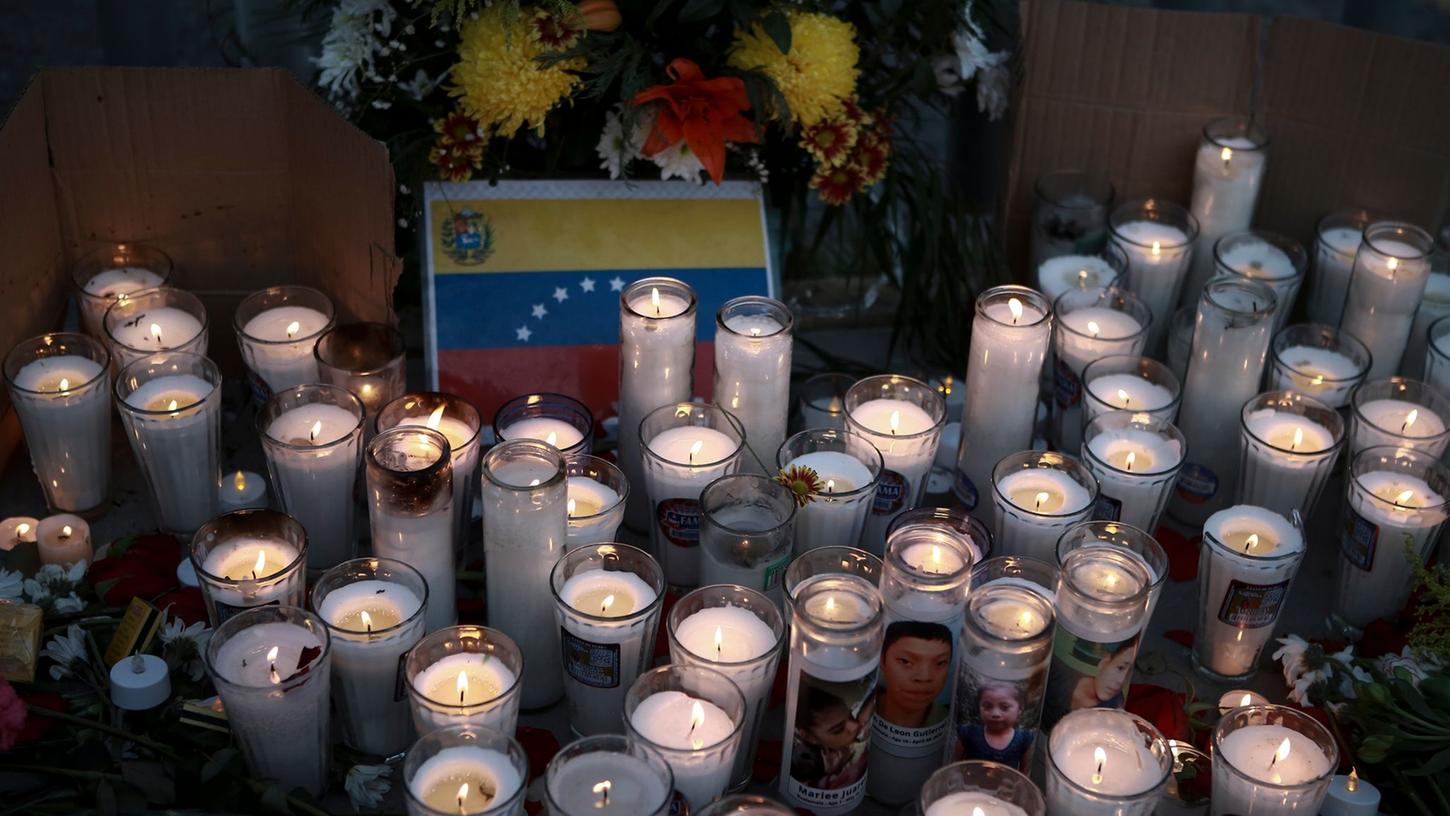 Kerzen stehen auf einem Altar während einer Mahnwache für die Opfer des Brandes.
