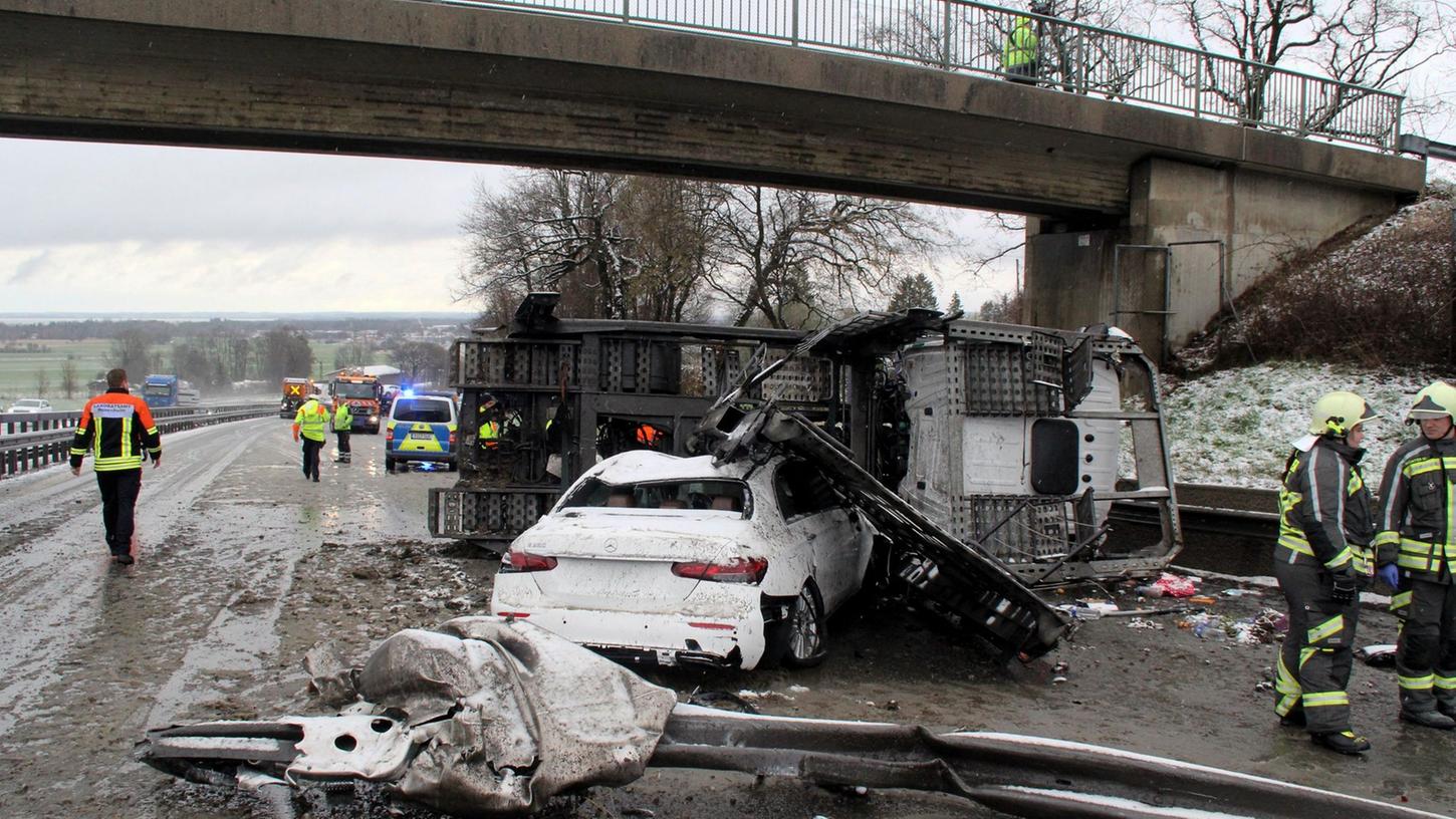 Einsatzkräfte stehen neben den Unfallfahrzeugen auf der A8.