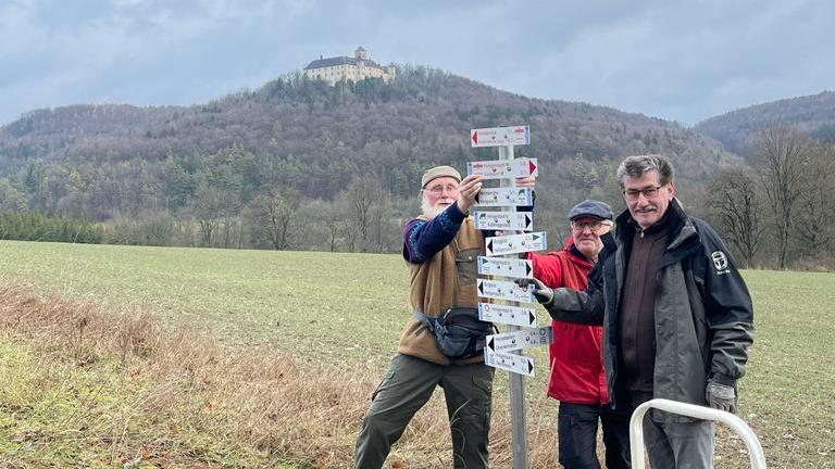 Die Ehrenamtlichen beim Ausrichten der Schilder unterhalb von Schloss Greifenstein
