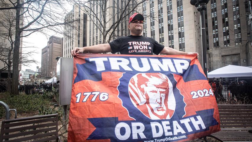 Die Demonstranten werteten die Anklage als rein politisch motiviert. Sie schwenkten Trump-Fahnen und hielten Schilder hoch, auf denen unter anderem "Hexenjagd" stand.