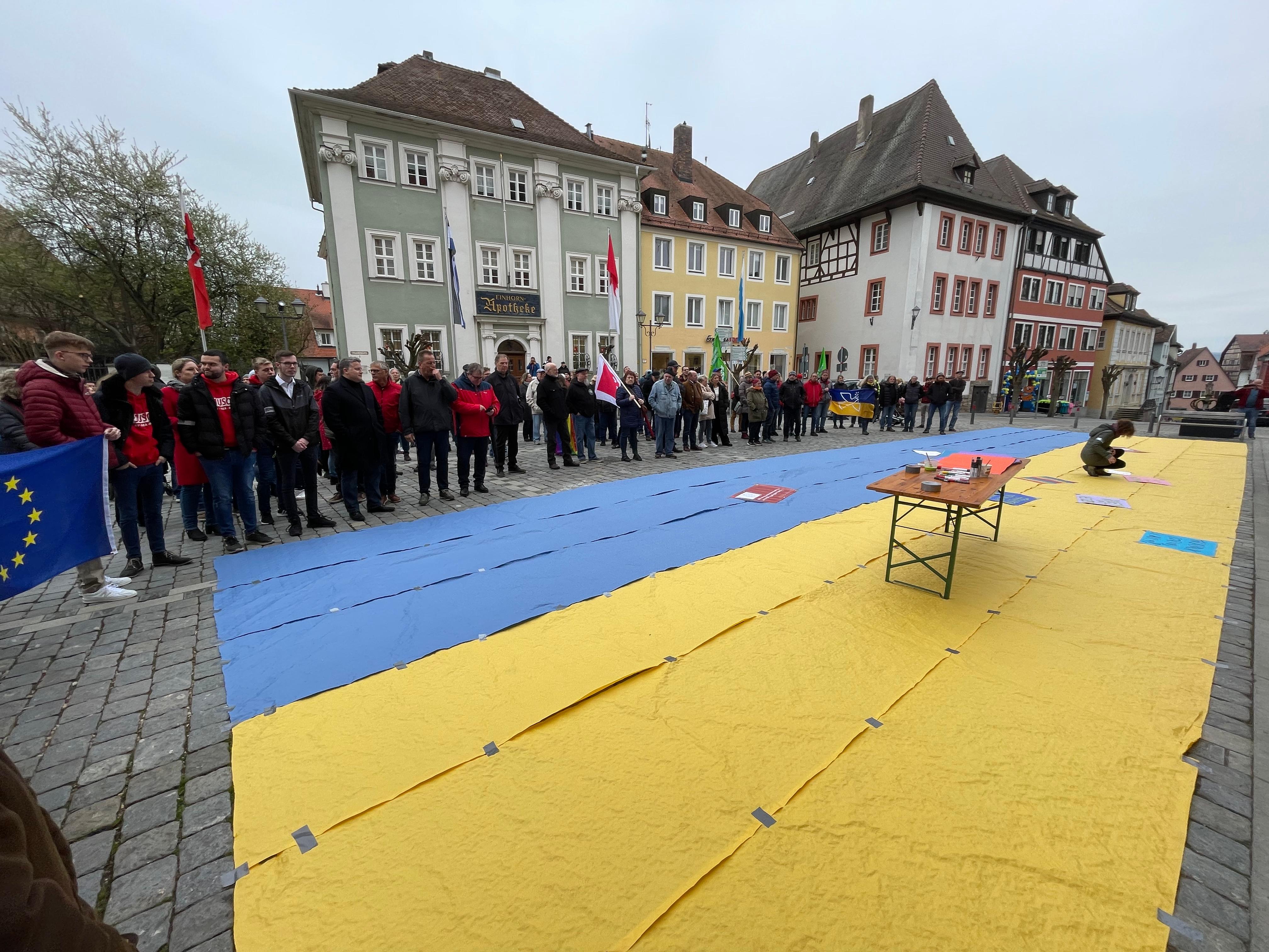 Die Redner und Rednerinnen von SPD und Grünen sowie von unterschiedlichen Organisationen brachten ihre Solidarität mit der Ukraine zum Ausdruck. Auf der Straßenzeitung in den ukrainischen Landesfarben konnten die Teilnehmer und Teilnehmerinnen der Veranstaltung zudem ihre Botschaften aufbringen.