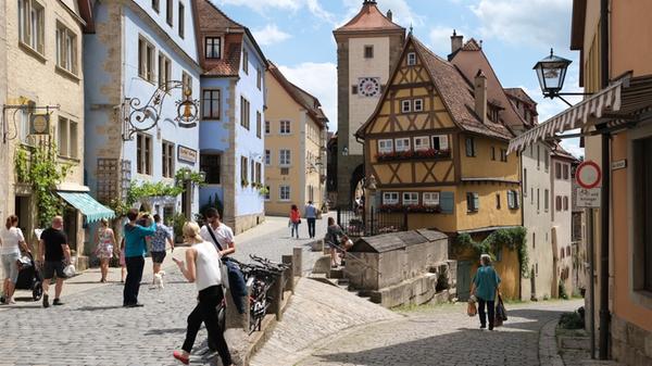 Das Plönlein gehört zu den meistfotografierten Sehenswürdigkeiten deutscher Städte und ist ganz vorne dabei bei den touristischen Zielen in Rothenburg. Das Ensemble gilt als ein Wahrzeichen der Altstadt, das weltweit bekannt ist. Im Mittelpunkt das leicht schräge historische Fachwerkhaus, links der Siebersturm, rechts führt der Weg ins Taubertal durch das Kobollzeller Tor, einst direkter Stadtzugang.