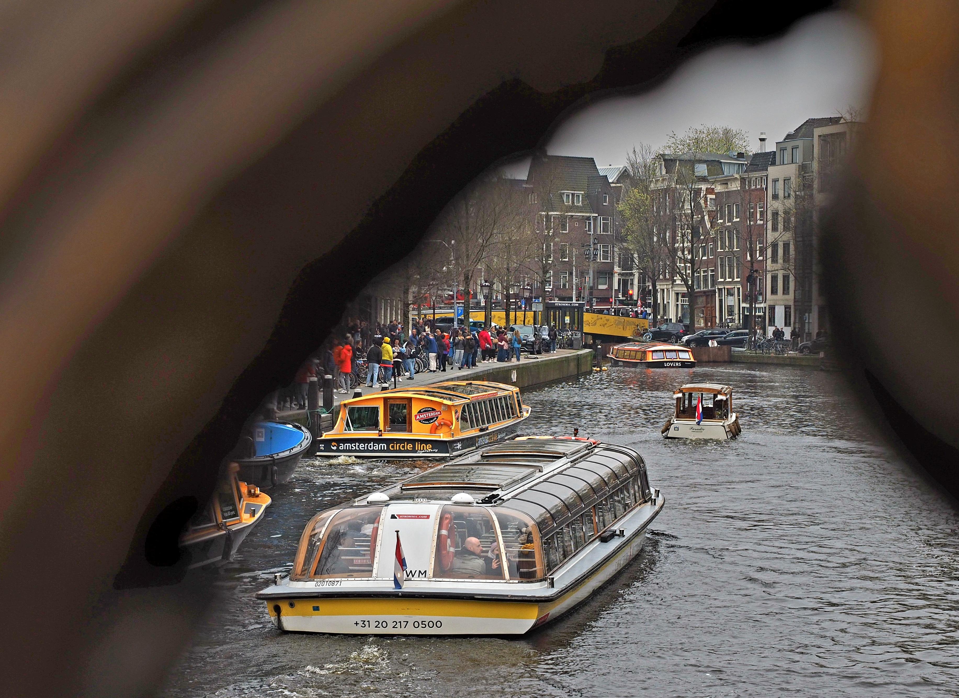 Typisches Amsterdam-Motiv: Boote auf den Grachten, viele Touristen unterwegs.