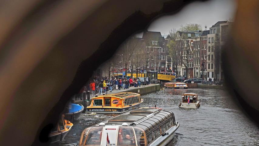 Typisches Amsterdam-Motiv: Boote auf den Grachten, viele Touristen unterwegs.