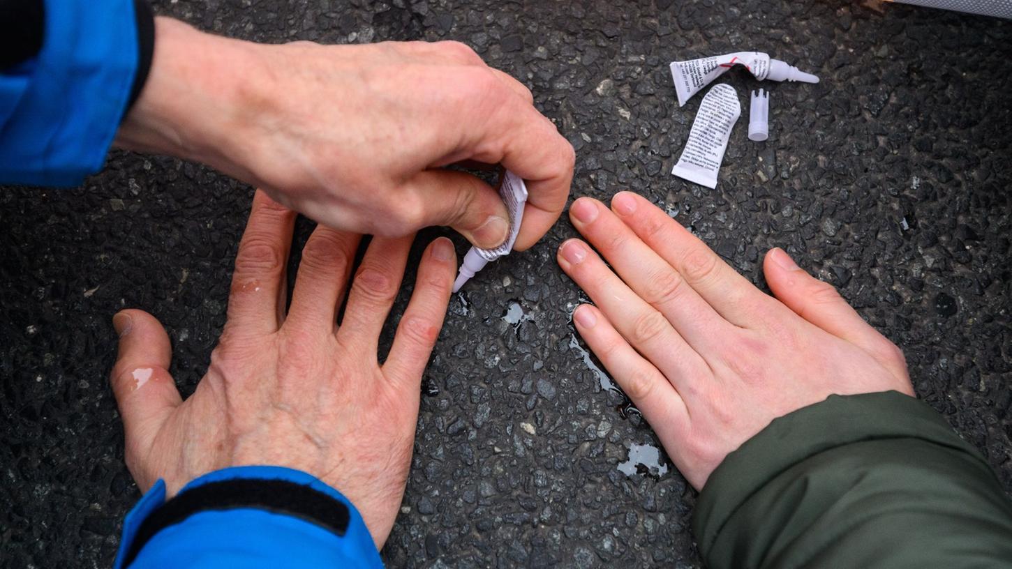 Aktivisten der Gruppierung "Letzte Generation" kleben ihre Hände auf die Straße und blockieren so den Verkehr. (Archivbild) Aktivisten der Gruppierung "Letzte Generation" kleben ihre Hände auf die Straße und blockieren so den Verkehr. (Archivbild)