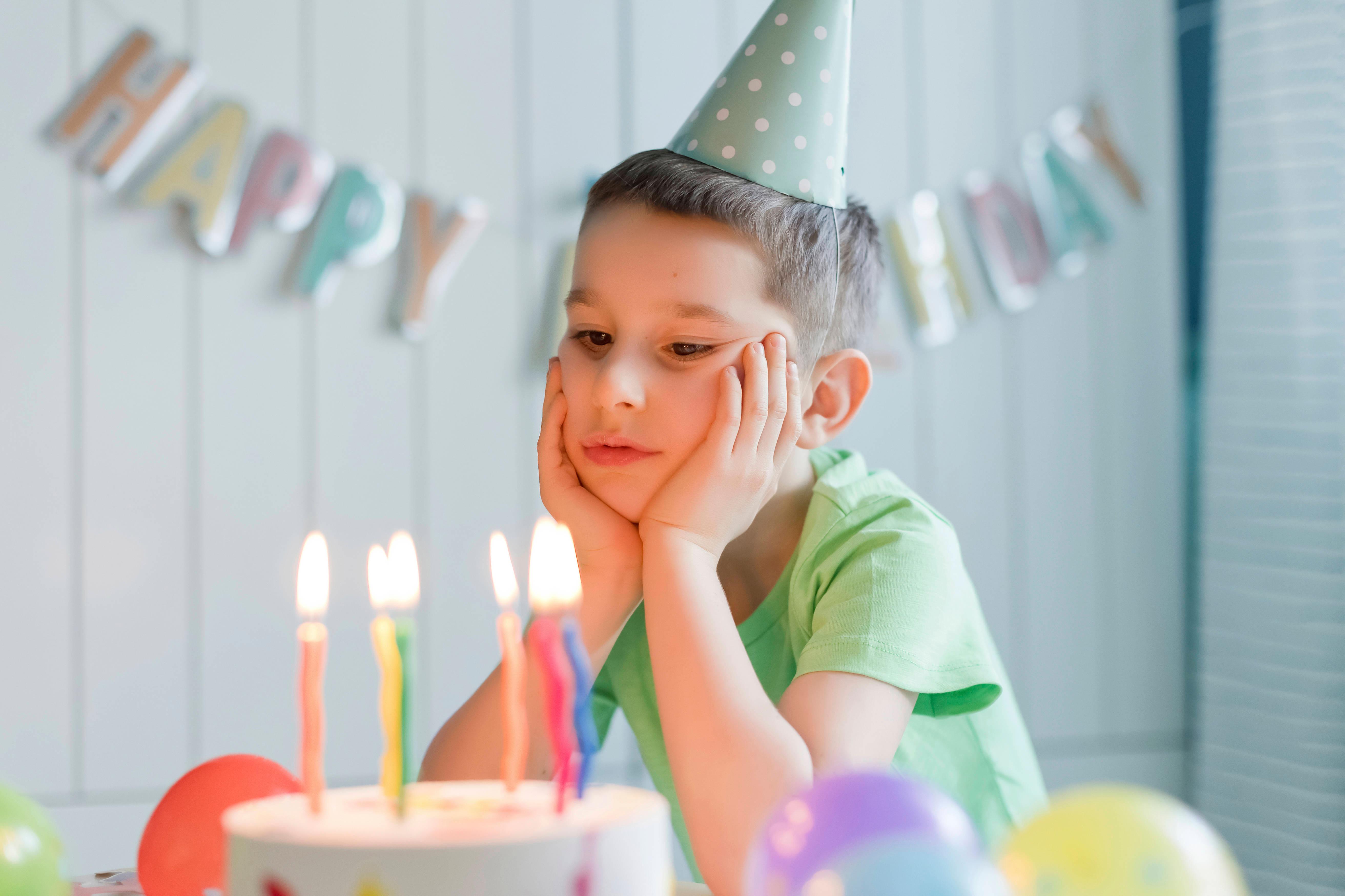 Junge schaut enttäuscht auf Torte