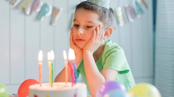 Junge schaut enttäuscht auf Torte
