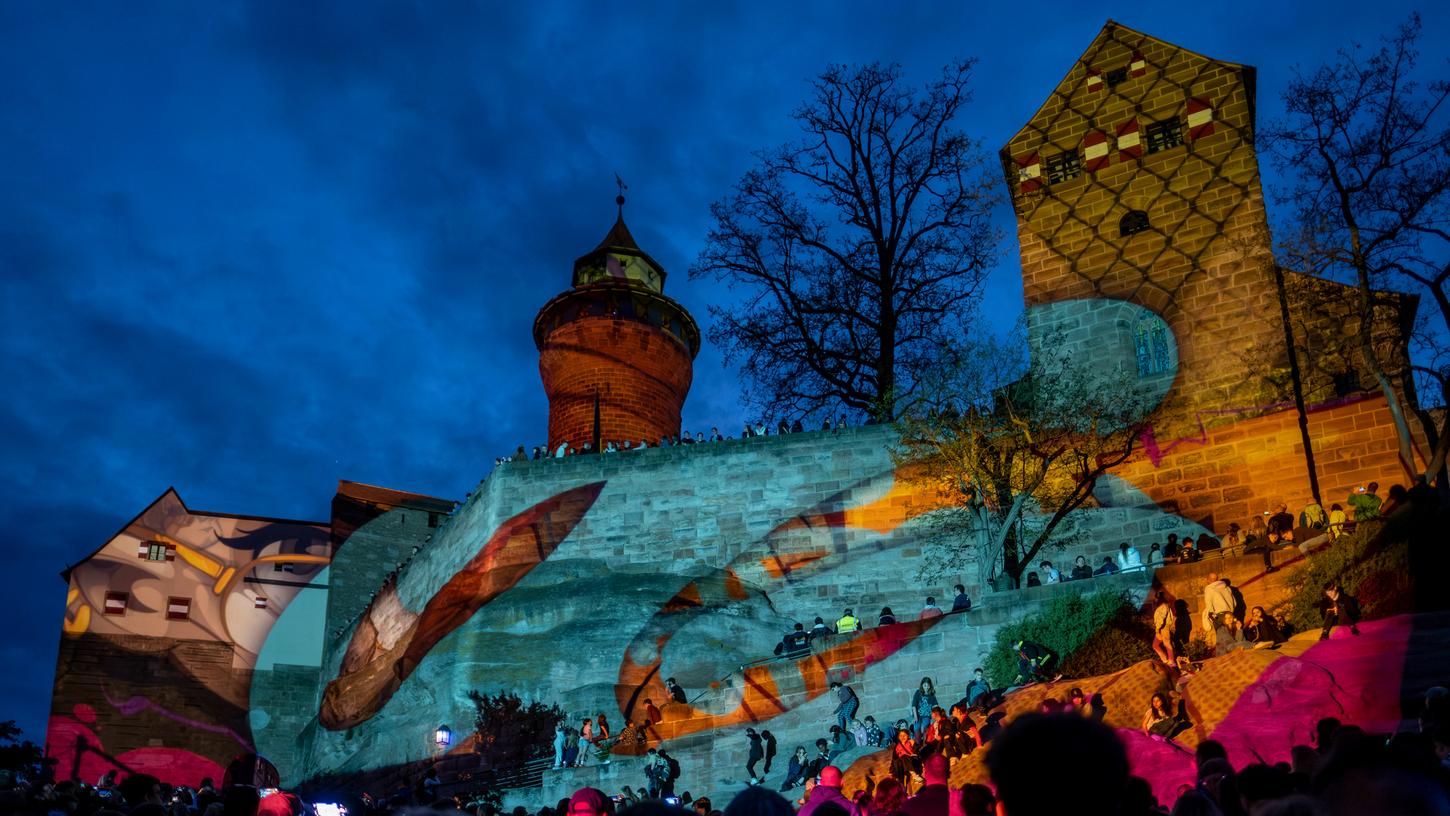 Der in Mannheim geborene Streetartist "Hombre SUK" hat 2023 im Rahmen der "Blauen Nacht" die Nürnberger Kaiserburg illuminiert.