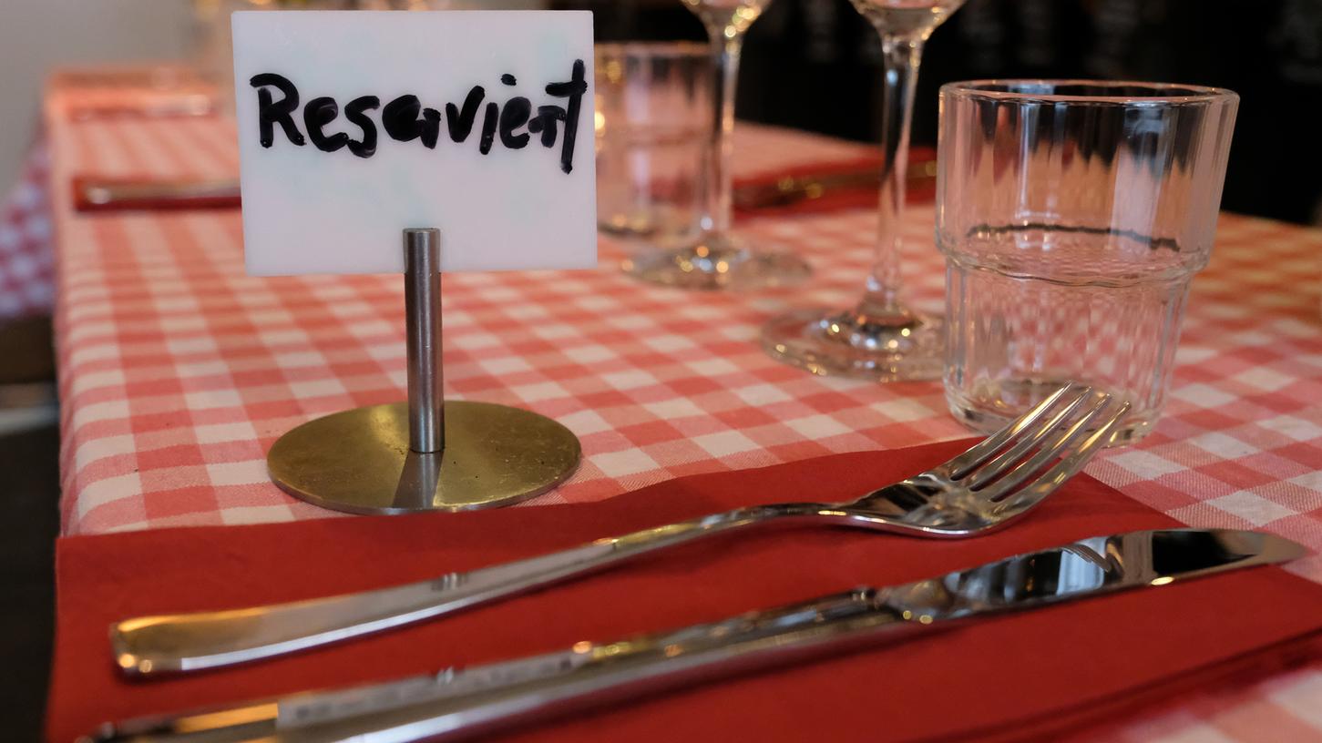 Ein Schild mit der Aufschrift «Reserviert» steht auf einem Tisch in einem Restaurant. Ein Schild mit der Aufschrift «Reserviert» steht auf einem Tisch in einem Restaurant.