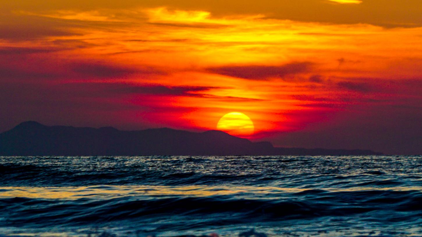 Stimmungsvoller Sonnenuntergang und Meer mit Wellen am Arachavi Strand Paralia Arachavi auf Korfu.